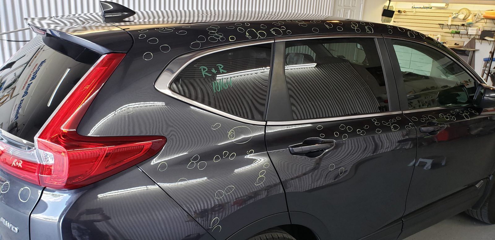 Hail damage across the side and roof panels of a silver SUV in Omaha