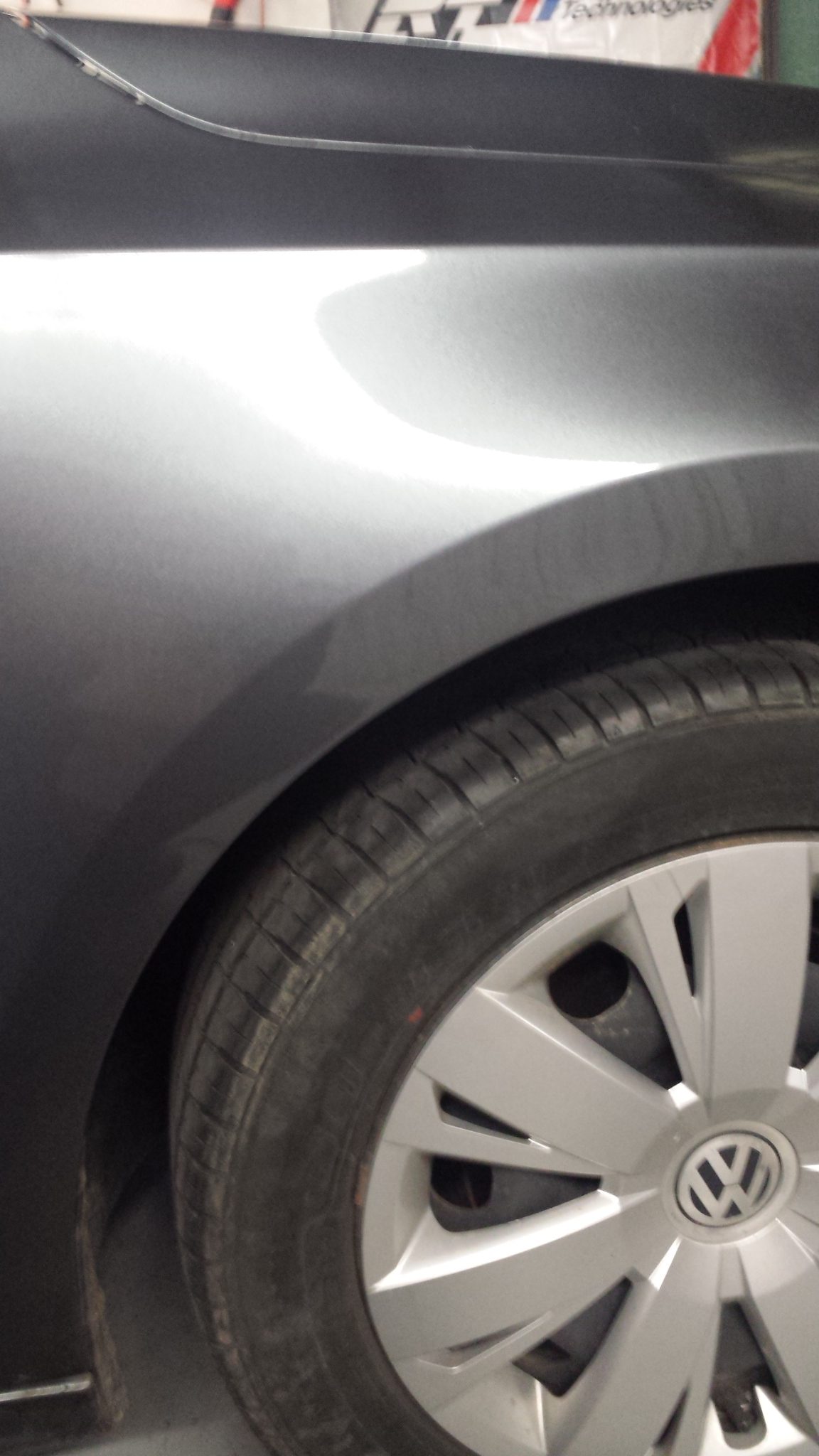 The same Volkswagen rear quarter panel after paintless dent repair, smooth and clean